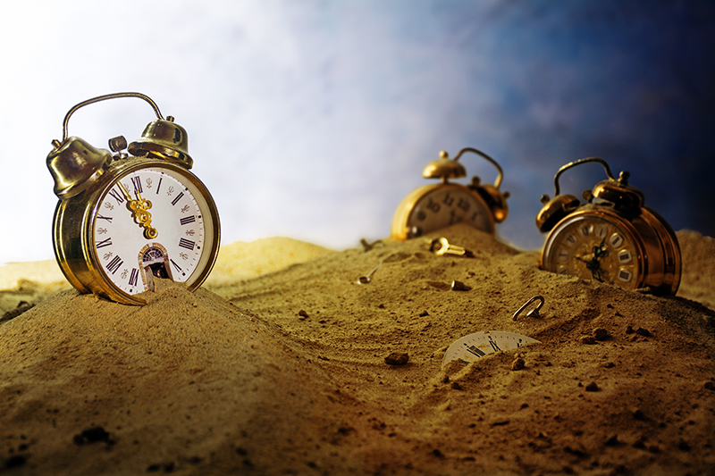 sand running out of an alarm clock, other watches sink into it,