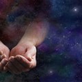 Our Abundant Universe – Male hands emerging from a wide dark dee
