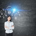 Girl with black hair near blackboard with blue light bulbs