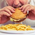 man eating burger and french fries