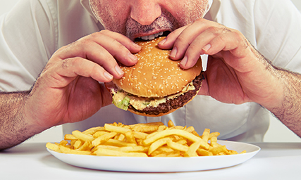 man eating burger and french fries