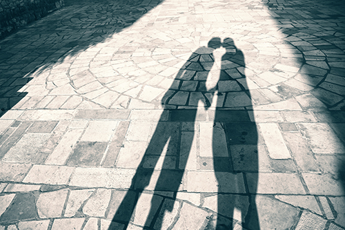 Silhouette shadow of two people holding hands and kissing backgr