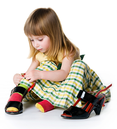 Little girl try on big shoes