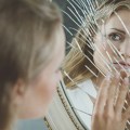 Woman touching broken mirror
