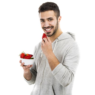 Happy young eating a strawberry