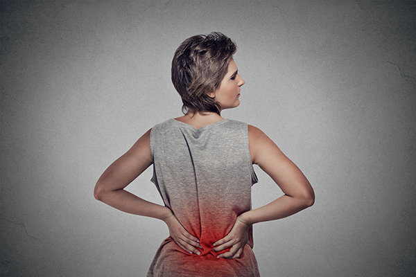 young woman with backache lower back pain colored in red