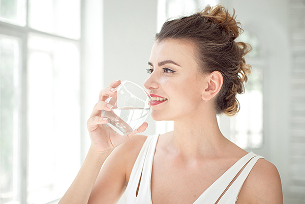 Portrait of a beautiful woman drinking water