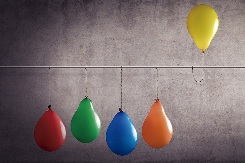 Ein Luftballon der aus einer Gruppe heraussticht