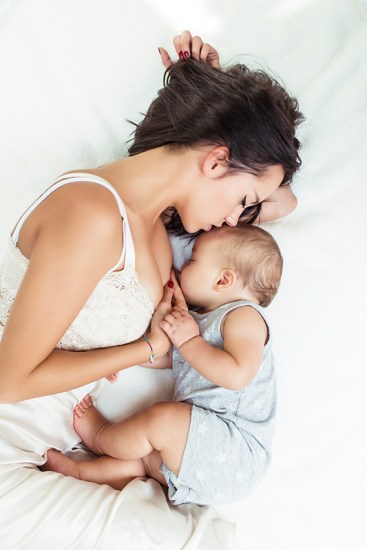 Beautiful mother brest feeding her cute little baby.