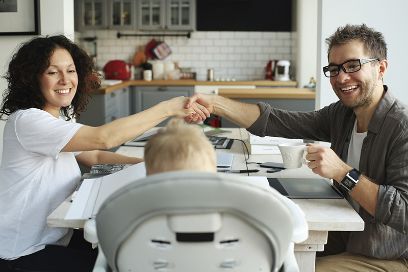 A little boy sits in a child seat with his parents