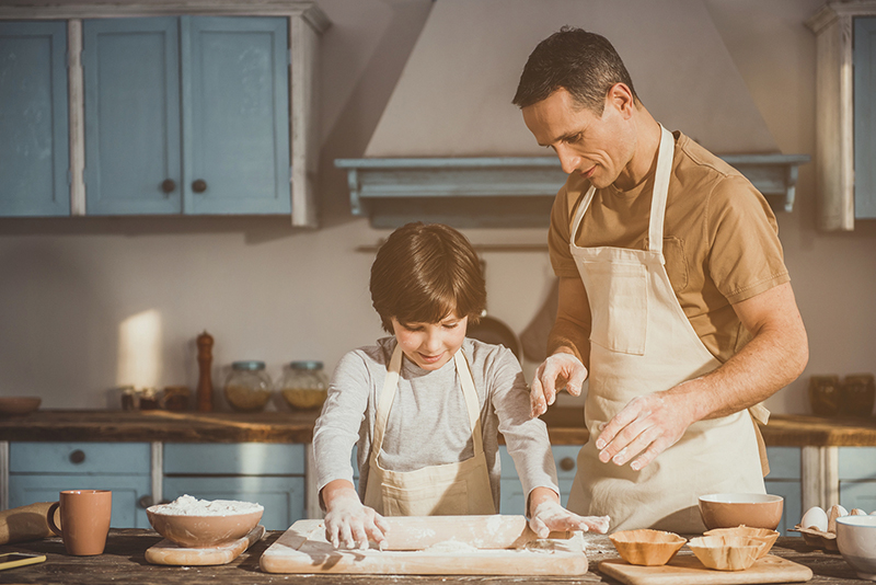 Kid and dad making dish for dessert