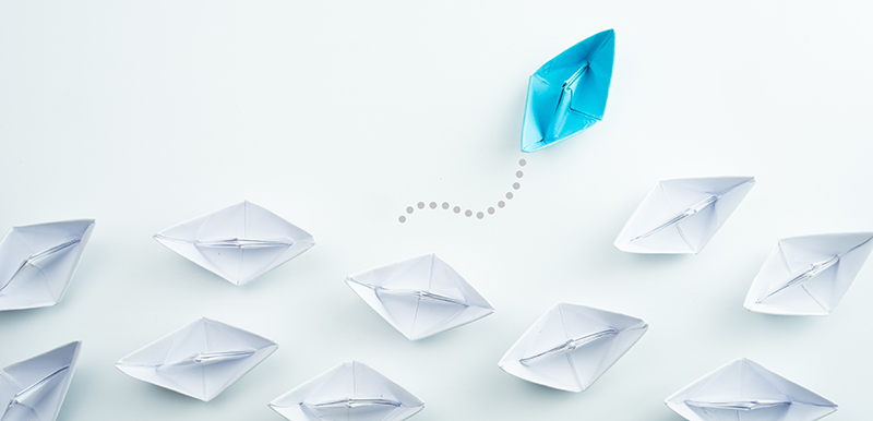 Business concept as a group of paper ship in one direction and w